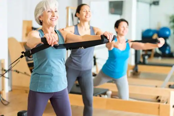 Toning Arms After 60: Empowering Womens Fitness Through Effective Weight Training 2 older woman doing weight training West Bromwich and resistance in the gym to tone upper arms